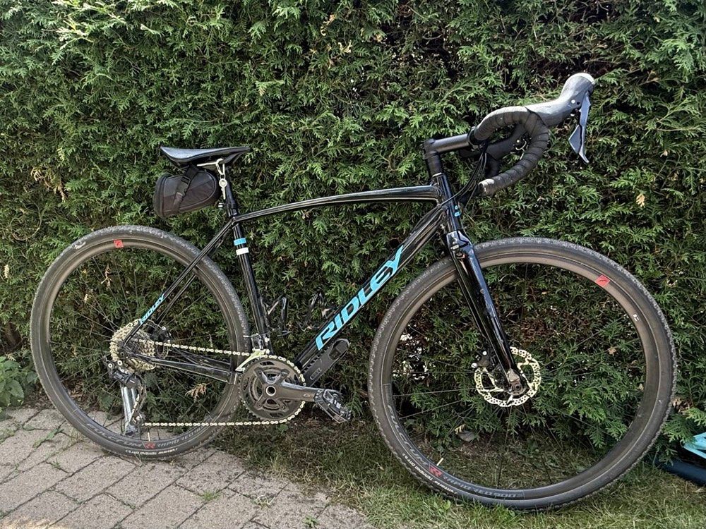 Gravelbike in schwarz mit hellblauen Akzenten – einsatzbereit für Stadt, Schotter und Bergtouren